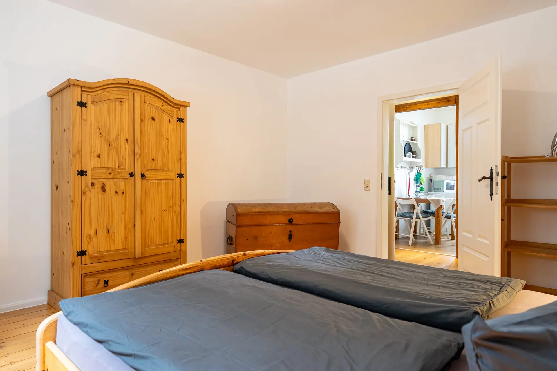 Holzschrank und Truhe im Schlafzimmer, Tür in die Küche